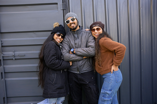 Happy indian group of friends wearing winter clothes and glasses Having fun. isolated on grey background.