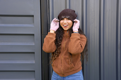 Cheerful Young indian woman enjoying in winter warm clothes with cap