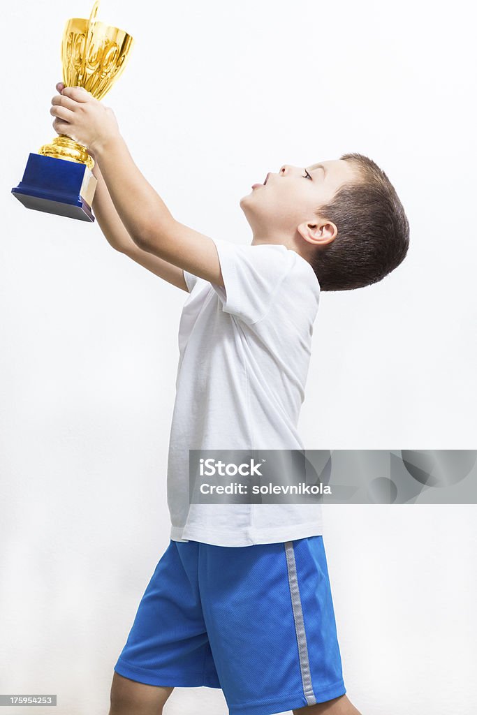 Little boy celebra su trofeo de oro - Foto de stock de Agarrar libre de derechos