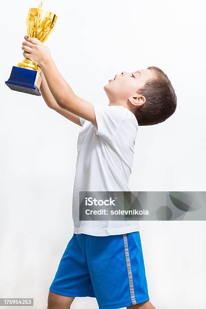 Little Boy Celebra Su Trofeo De Oro Foto de stock y más banco de imágenes de Agarrar - Agarrar, Alegre, Blanco - Color