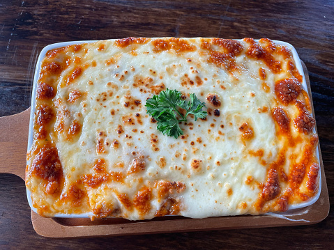 Fresh hot lasagna serve with baking dish.
