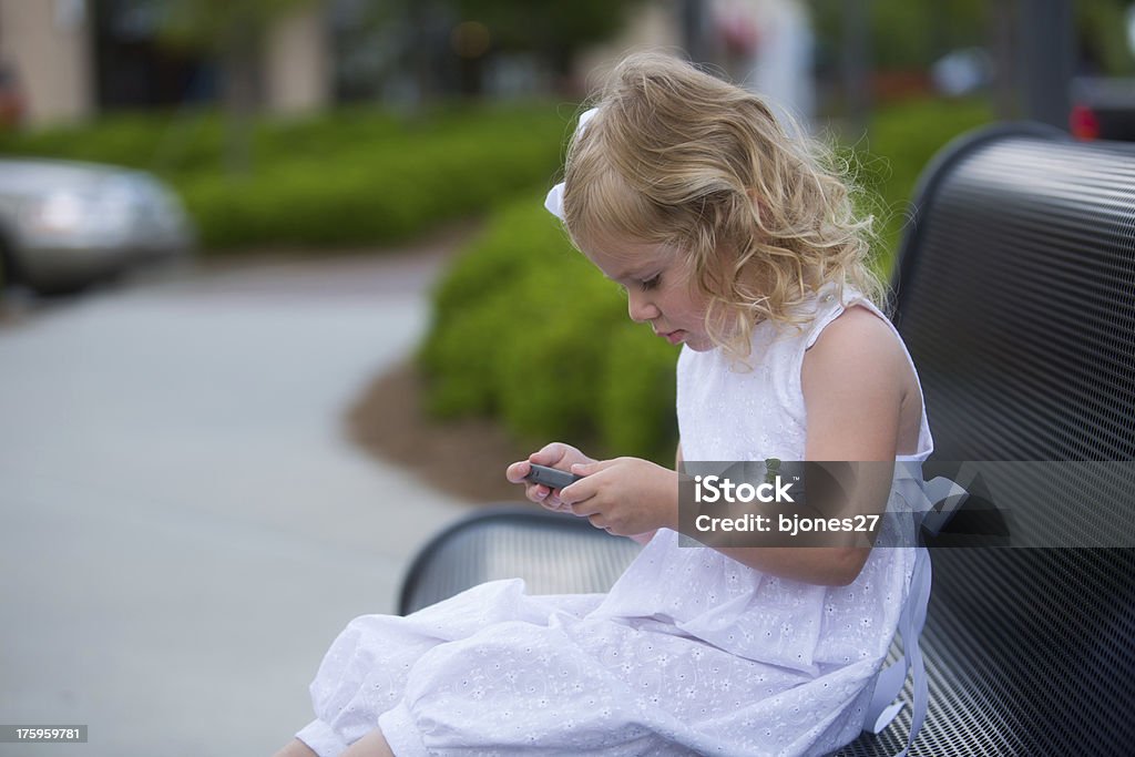 Petite fille jouant avec son smartphone - Photo de Beauté libre de droits