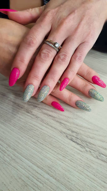 istock Acrylic nail extensions, manicure, nail correction, hands in the foreground. Reflective design. 1759601493