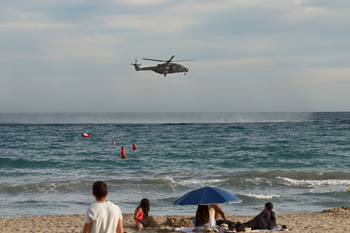 Alicante, Spain, 10-26-2023. 
Helicopter and military boat performing maneuvers on Postiguet beach in Alicante, Spain