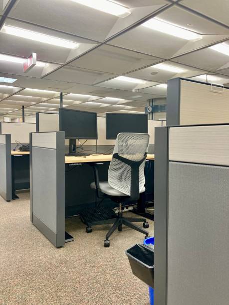 An empty cubicle, early morning in the office. An early morning capture of a classic cubicle office space. office cubicle no people stock pictures, royalty-free photos & images