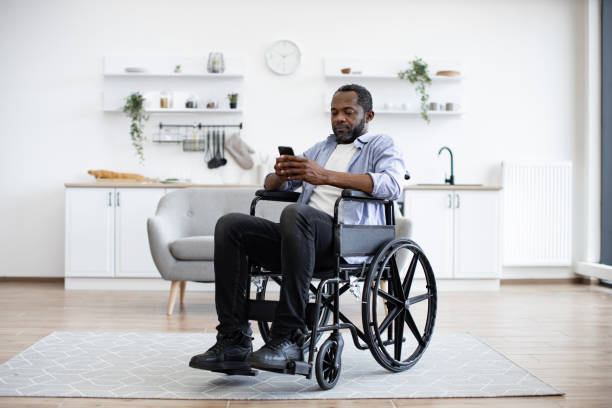 istock Male with disability texting message on phone in dining room 1759612837
