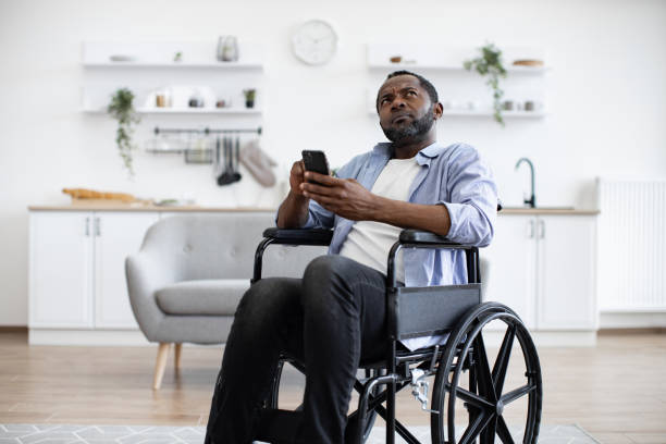 istock Male with disability texting message on phone in dining room 1759613355