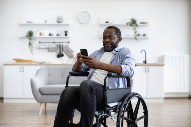 istock Male with disability texting message on phone in dining room 1759613367