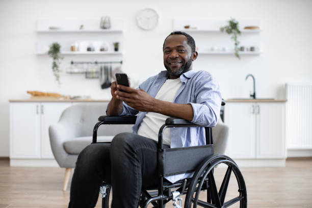 istock Male with disability texting message on phone in dining room 1759613823