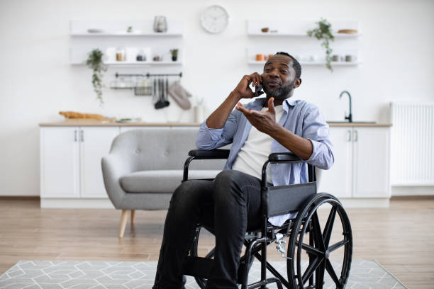 istock Male with mobility impairment speaking on mobile in kitchen 1759613904