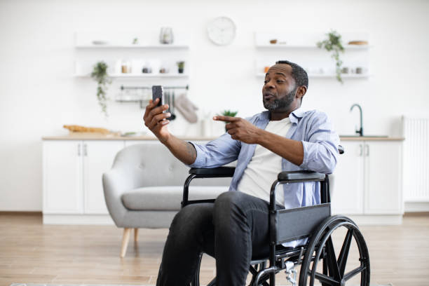 istock Wheelchair user holding online conference in home interior 1759613918