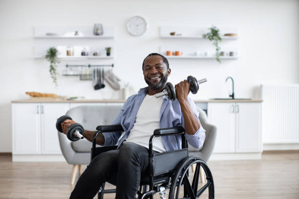 istock Man in wheelchair with weights smiling at camera indoors 1759614511