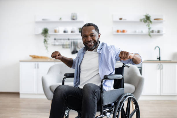 istock Joyous bearded man in wheelchair exercising stretching arms 1759615605
