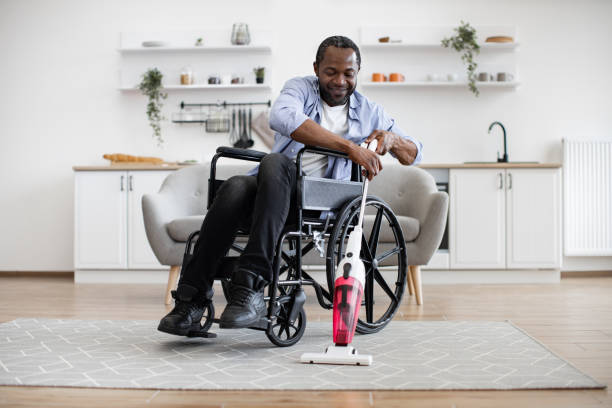 istock Man with mobility impairment housekeeping with stick vacuum 1759616194