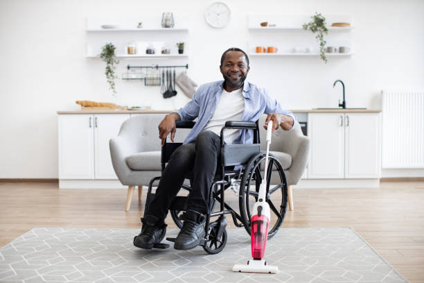 istock Man with mobility impairment housekeeping with stick vacuum 1759616698