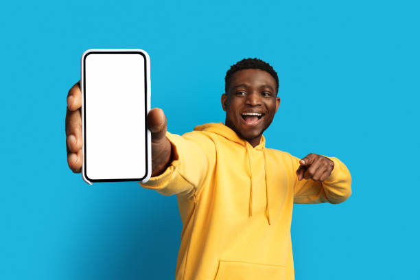 istock Excited young black guy showing smartphone with mockup 1759617767