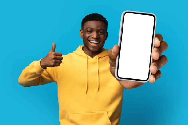istock Positive african guy showing cell phone and thumb up, mockup 1759619361