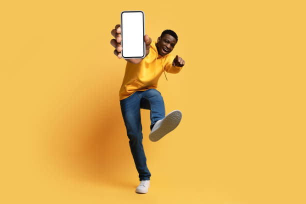 istock Cool black guy showing smartphone mockup and thumb up 1759619872