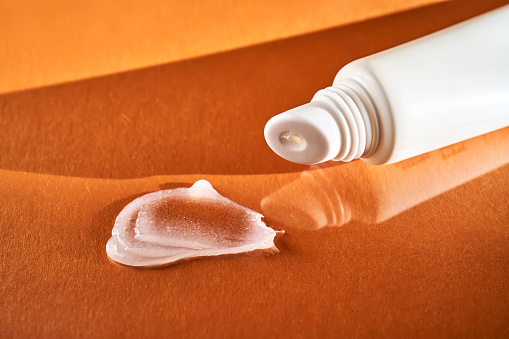 Hygienic moisturizing lip balm in a tube on a orange background. Great product photo for your business.