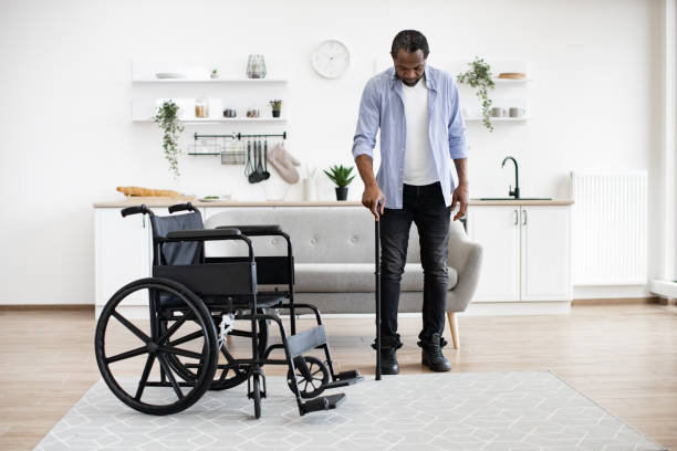 istock African man with disability using walking stick when raising from wheelchair 1759623393