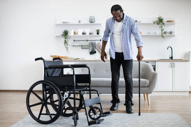 istock African man with disability using walking stick when raising from wheelchair 1759623436