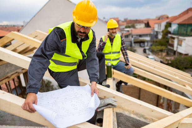 istock Caucasian roofer looking at the blueprint, at the construction site 1759632683