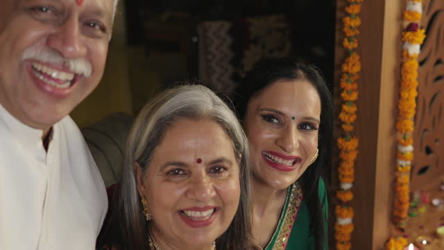 Senior man taking selfie with family at home during Diwali