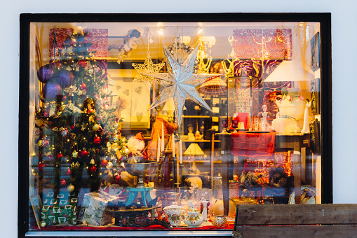Scenic view of the city street and the Christmas atmosphere in the town with the store window decorated by Christmas decoration and presents
