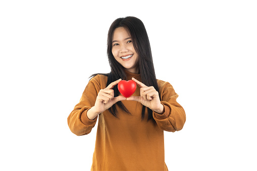 Asian Young Woman holding red heart isolated on white background with clipping path. health insurance, donation, happy charity volunteer concept, world mental health day, world heart day, self care, csv concept