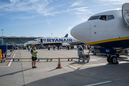 A Ryanair plane at Stansted Airport in London, heading to Wroclaw on a sunny autumn day, waiting to complete boarding.