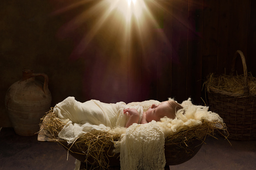 Live Christmas nativity scene of 8 days old baby boy sleeping in a manger