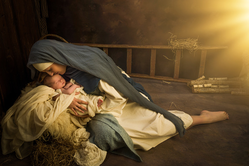 Living Christmas Nativity Scene of parents dressed in authentic clothes, with their 9 days old baby boy in swaddles