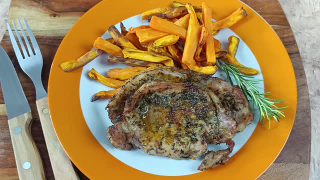 pork steak and sweet potato fries on a plate