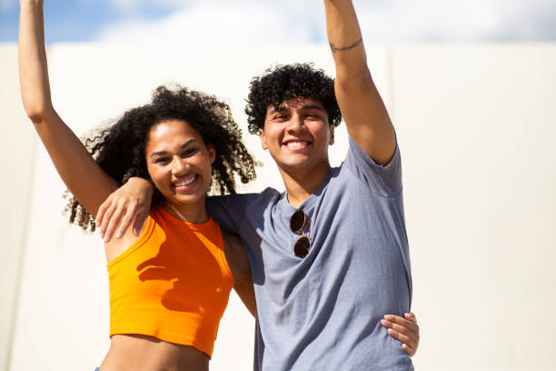 istock smiling young couple with arms raised 1759736369