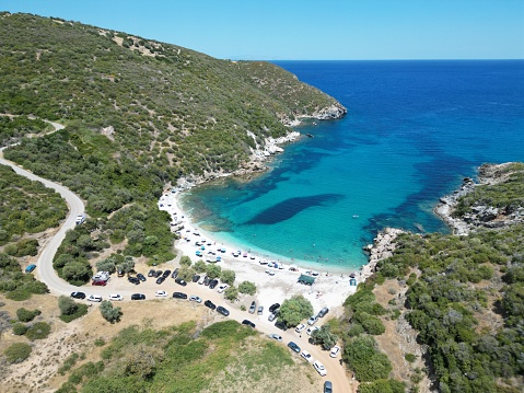 This stunning high-resolution photograph captures the unspoiled beauty of Evia's mesmerizing coastline, one of Greece’s most picturesque and serene destinations. The frame is filled with the vibrant colors of the Aegean Sea, meeting the rugged cliffs and lush vegetation that characterize this enchanting region.\n\nThe camera angle offers a sweeping view of the coastline, providing a sense of the expansive beauty and tranquility that awaits visitors. The crystal-clear waters sparkle under the warmth of the Greek sun, inviting onlookers to dive in and explore the hidden treasures beneath the surface.