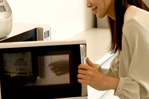 istock Young Asian woman using microwave in the kitchen 1759770553