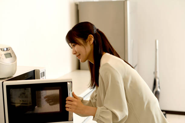 istock Young Asian woman using microwave in the kitchen 1759774799