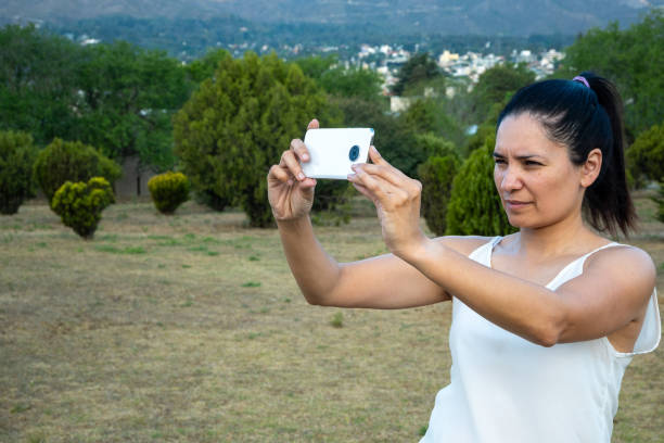 istock Latin woman using her cell phone in a park. 1759785388
