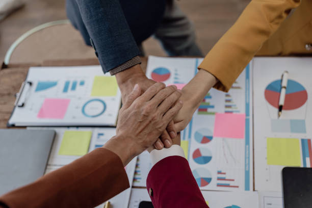 istock Teamwork hands on financial graph document in conference room, business team join hands to show goodwill of working together. 1759789506