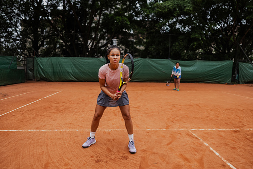 Mid adult woman playing tennis in a clay court