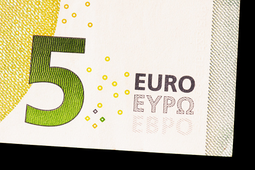 The bottom right corner of a five Euro note, with the text Euro in the Latin, Greek and Cyrillic alphabets.