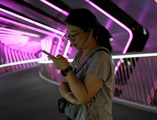 istock Young woman using cell phone on pedestrian bridge 1759858354