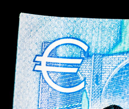 Macro image of the Euro symbol in the top corner of a Twenty Euro banknote.