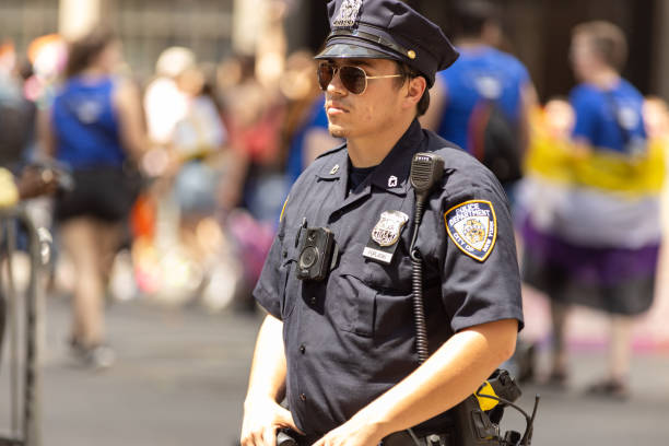 policial de nypd na marcha do orgulho de nova york - flag gay man american culture rainbow - fotografias e filmes do acervo