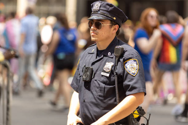 policial de nypd na marcha do orgulho de nova york - flag gay man american culture rainbow - fotografias e filmes do acervo