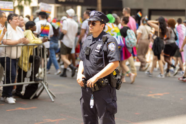 policial de nypd na marcha do orgulho de nova york - flag gay man american culture rainbow - fotografias e filmes do acervo