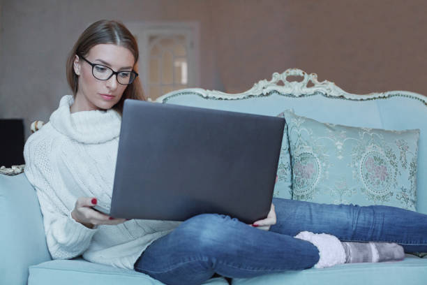 istock Serious woman in glasses working using laptop at home 1759870680