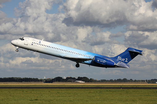 Photo of an airplane just before landing in the early morning. Runway lights can be seen in the foreground.