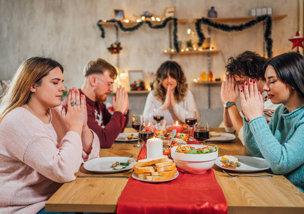 istock Friends praying before eating Christmas dinner 1759900200