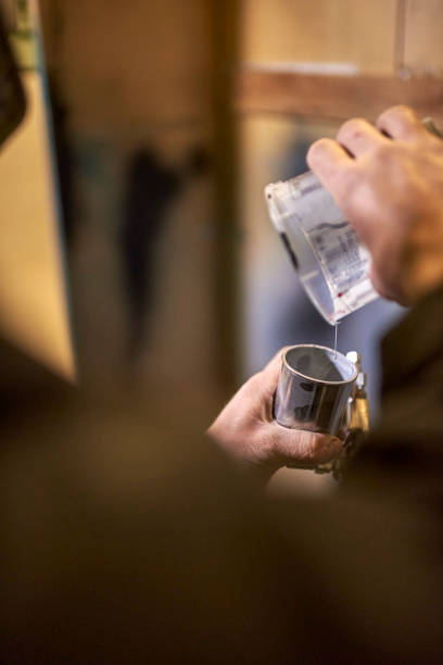 istock Unrecognizable person pouring paint into a spray paint gun tank in his workshop 1759901266